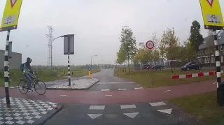 Fietser kijkt niet om zich heen en belandt bijna op de motorkap